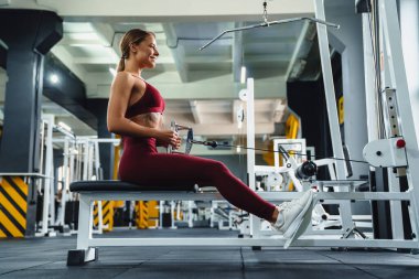 Spor salonunda spor yaparken spor yaparken gülümseyen sporcu kadın.