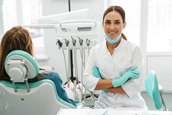 在牙科诊所与病人共事时 欧洲的中级牙医妇女面带微笑 — 图库照片