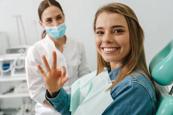 Jovem Europeia Mostrando Sinal Enquanto Sentado Cadeira Médica Clínica Odontológica — Fotografia de Stock