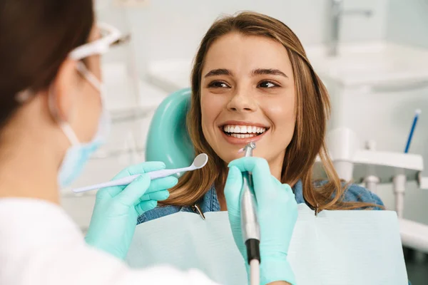 Europeu Sorrindo Mulher Sentada Cadeira Médica Enquanto Dentista Fixar Dentes — Fotografia de Stock