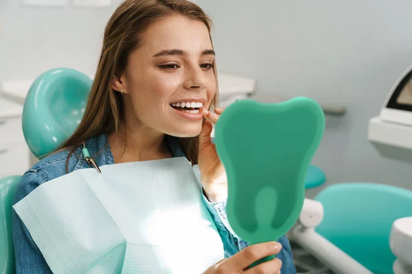Mujer Joven Europea Sonriendo Mientras Mira Espejo Clínica Dental — Foto de Stock