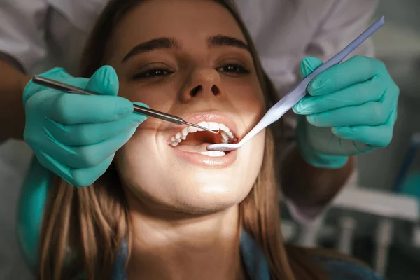 Европейская Молодая Женщина Сидящая Медицинском Кресле Пока Стоматолог Чинит Зубы — стоковое фото