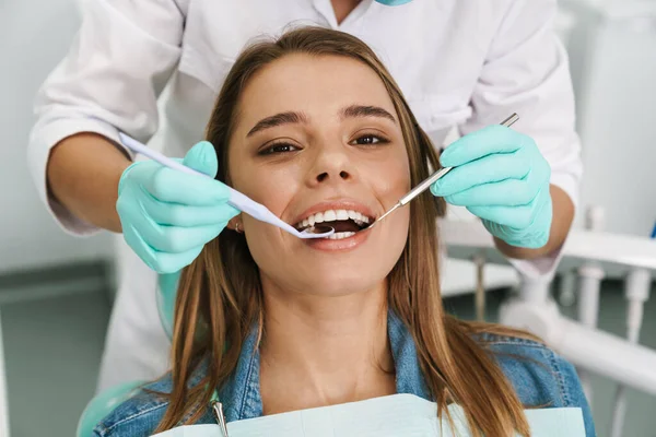 Jovem Europeia Sentada Cadeira Médica Enquanto Dentista Fixa Dentes Clínica — Fotografia de Stock