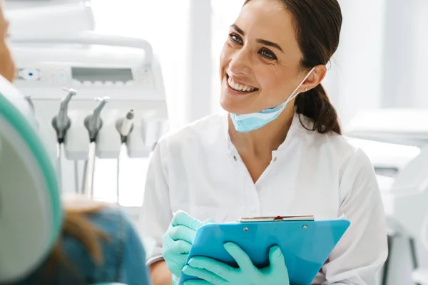 Europeo Mid Dentista Donna Sorridente Mentre Lavora Con Paziente Clinica — Foto Stock