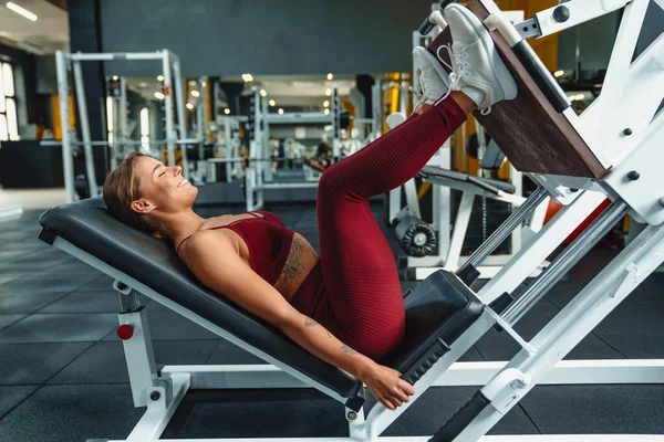 Spor Salonunda Bacaklar Için Spor Egzersizleri Yapan Konsantre Genç Kadın — Stok fotoğraf