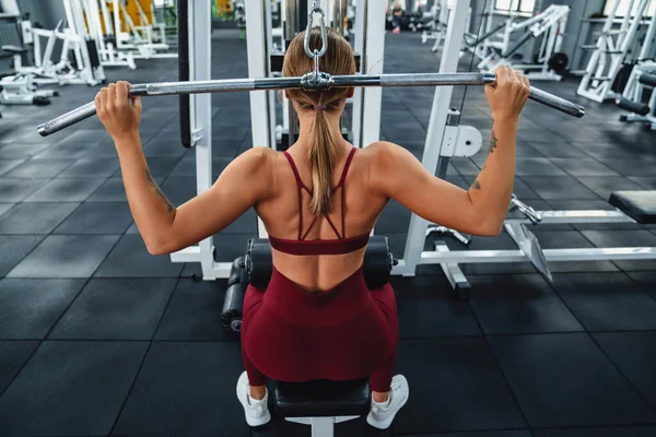 白种人女运动员在健身房锻炼的时候 用健身器材进行运动 — 图库照片