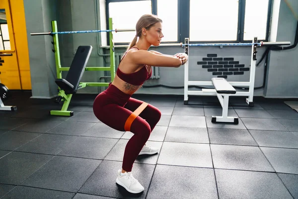 白种人女运动员在健身房锻炼的同时 还与膨胀机一起做运动 — 图库照片