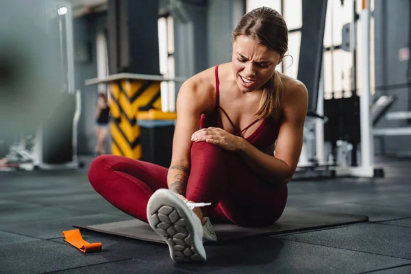 Negativ Aufgeladene Junge Fitnesstrainerin Mit Schmerzen Bein Fitnessstudio — Stockfoto