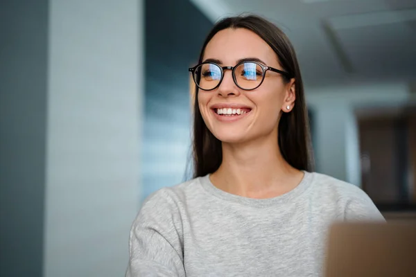 Glad Ung Kvinna Glasögon Ler Medan Arbetar Med Bärbar Dator — Stockfoto