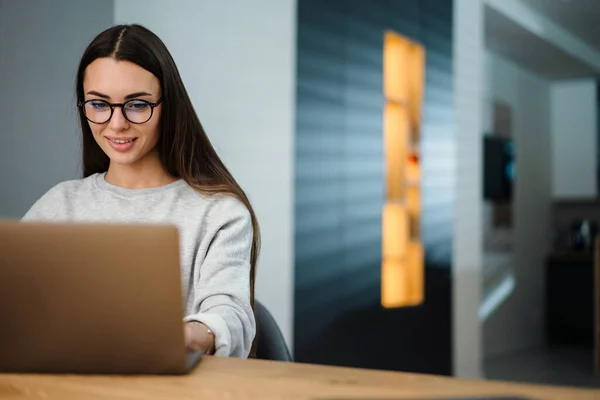 Glad Ung Kvinna Glasögon Ler Medan Arbetar Med Bärbar Dator — Stockfoto