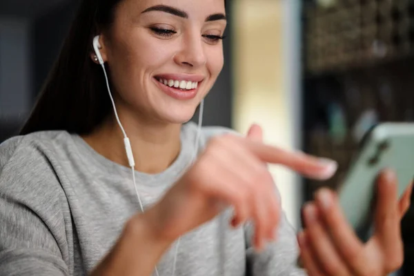 Ευτυχισμένη Νεαρή Γυναίκα Ακούει Μουσική Ακουστικά Και Κινητό Τηλέφωνο Ενώ — Φωτογραφία Αρχείου