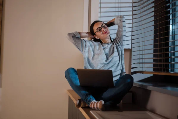 Glückliche Frau Mit Kopfhörern Die Mit Laptop Arbeitet Während Sie — Stockfoto