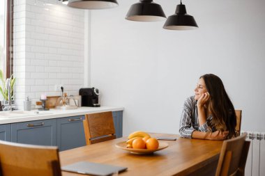 Mutlu, güzel bir kadın evde otururken gülümsüyor.