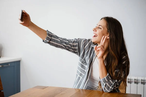 Lykkelig Vakker Kvinne Som Viser Fredstegn Mens Hun Tar Selfie – stockfoto