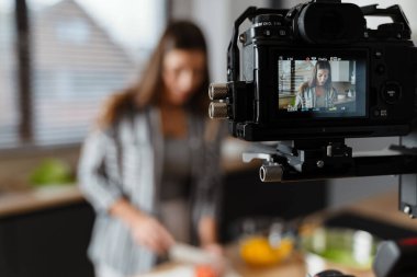 Beyaz kadının evdeki rahat mutfakta salata hazırlarken çekilmiş kamera görüntüleri.