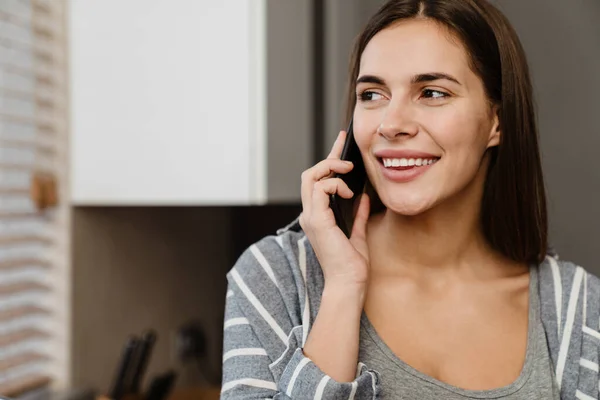 Mulher Feliz Encantadora Sorrindo Enquanto Fala Telefone Celular Cozinha Acolhedora — Fotografia de Stock