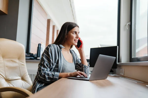 Mulher Feliz Encantadora Falando Celular Enquanto Trabalhava Com Laptop Casa — Fotografia de Stock