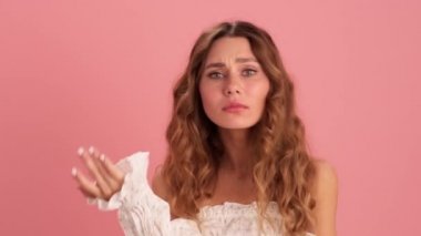 Kızgın bir kadın bir şeyler kanıtlıyor ve pembe stüdyodaki kameraya vıdı vıdı jest yapıyor.
