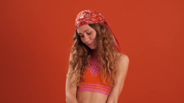 Die Verlegen Gelockte Frau Mit Kopftuch Schaut Orangefarbenen Studio Nach — Stockvideo