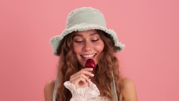 Μια Κοντινή Θέα Της Σγουρομάλλας Γυναίκας Καπέλο Που Τρώει Φράουλα — Αρχείο Βίντεο