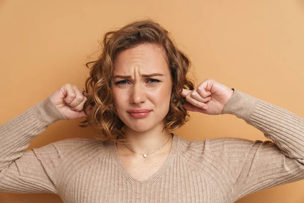 Unhappy Ginger Woman Frowning Plugging Her Ears Isolated Beige Background — 图库照片