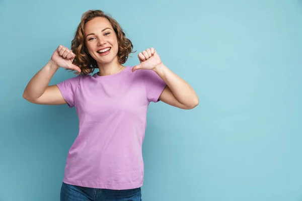 Junge Ingwerfrau Mit Welligem Haar Lächelt Und Zeigt Mit Dem — Stockfoto