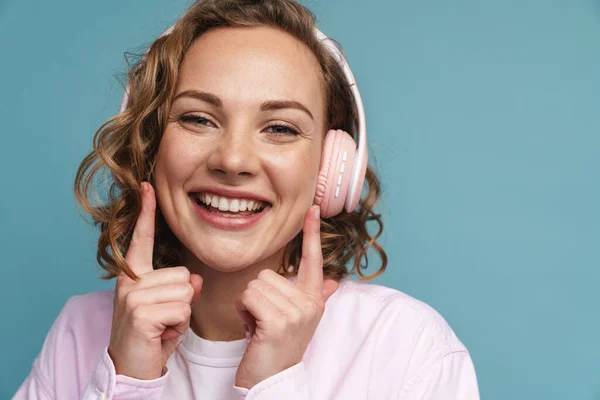 Joven Pelirroja Con Auriculares Apuntando Con Dedo Sus Mejillas Aisladas —  Fotos de Stock