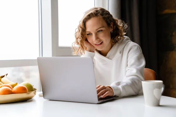 Λευκή Ξανθιά Γυναίκα Χαμογελώντας Και Πληκτρολογώντας Στο Φορητό Υπολογιστή Ενώ — Φωτογραφία Αρχείου