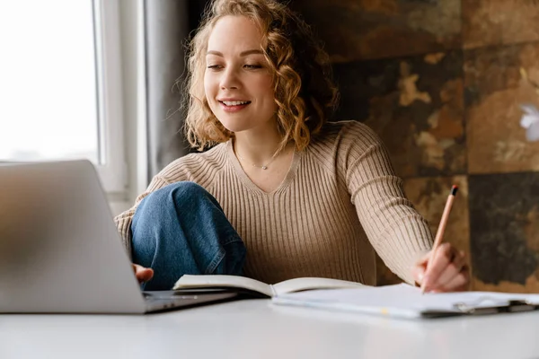 Mujer Blanca Joven Escribiendo Notas Mientras Trabaja Con Ordenador Portátil — Foto de Stock