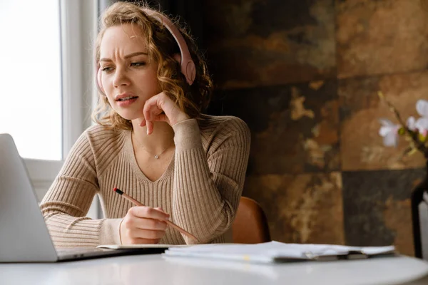 Jeune Femme Dans Les Écouteurs Note Tout Travaillant Avec Ordinateur — Photo