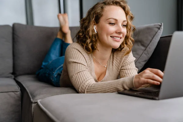 Weiße Blonde Frau Lächelt Und Benutzt Laptop Während Sie Hause — Stockfoto