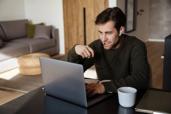 Poważny Mężczyzna Średnim Wieku Pracuje Laptopie Domu Myśląc — Zdjęcie stockowe