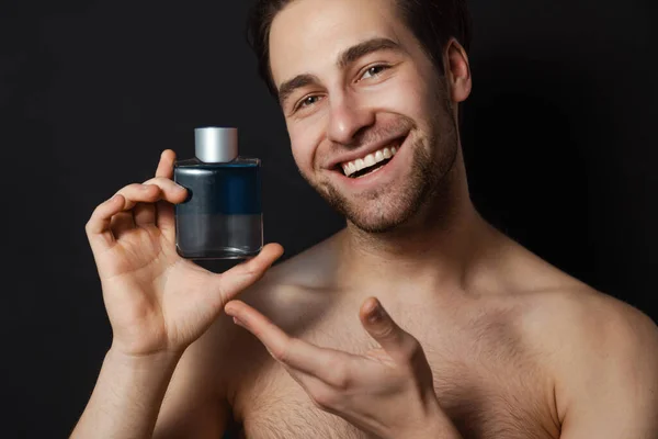 Shirtless White Man Smiling While Showing Cologne Isolated Blue Wall — Stock Photo, Image