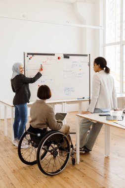 Ofiste çalışırken projeyi tartışan üç çok ırklı kadın