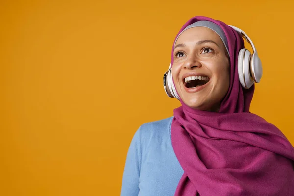 Lähi Idän Nainen Hijabissa Hymyilee Käyttää Kuulokkeita Eristetty Keltaisella Taustalla — kuvapankkivalokuva