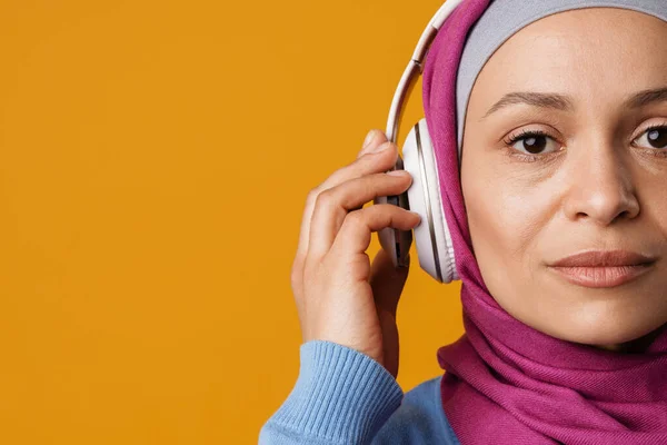 Lähi Idän Nainen Hijabissa Kuuntelemassa Musiikkia Kuulokkeet Eristetty Keltaisella Taustalla — kuvapankkivalokuva