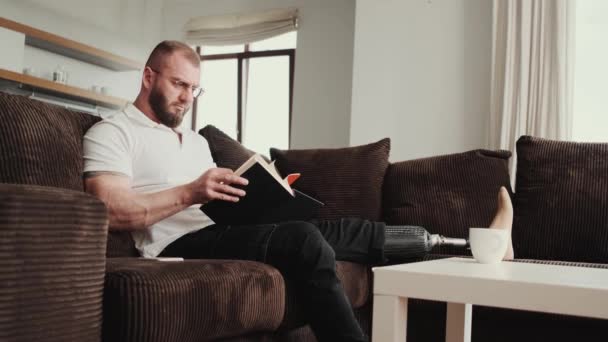 Koncentrerad Man Läser Bok Sittandes Soffan Hemma — Stockvideo