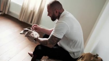 A top view of a disabled military man is holding his uniform while thinking about something sitting at home