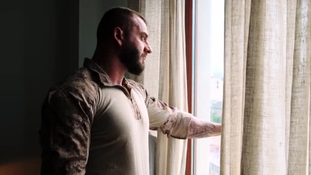 Wojskowy Patrzy Przez Okno Stojąc Domu — Wideo stockowe