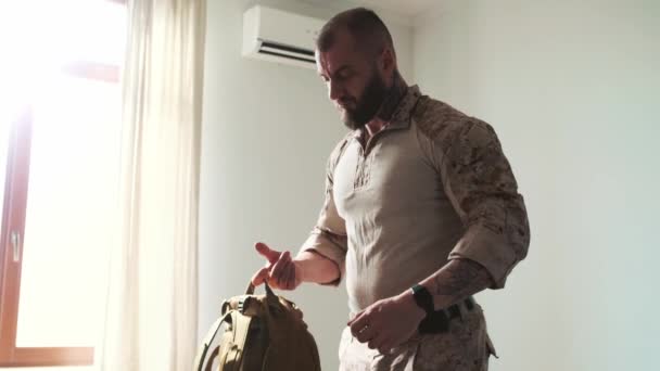 Ένας Σοβαρός Στρατιωτικός Που Φοράει Στολή Παίρνει Σακίδιό Του Και — Αρχείο Βίντεο