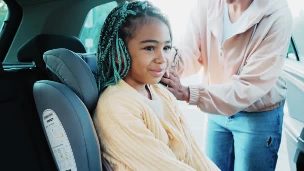 Eine Glückliche Afrikanisch Amerikanische Frau Setzt Ihre Tochter Den Kinderautositz — Stockvideo