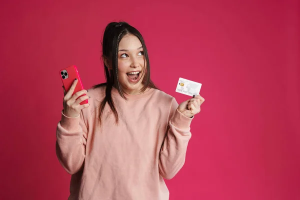 アジアのブルネット励起女性ポーズとともに携帯電話とクレジットカード孤立以上紫壁 — ストック写真