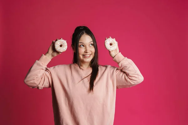 Glad Ung Kvinna Poserar Innehav Munkar Över Rosa Vägg Bakgrund — Stockfoto