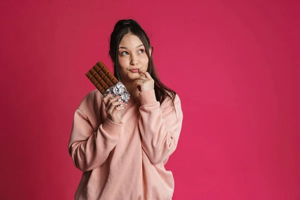 Pensiv Frestad Ung Kvinna Som Håller Chokladkaka Stående Över Rosa — Stockfoto