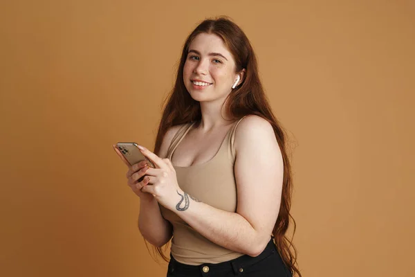 Sorrindo Jovem Size Mulher Segurando Telefone Celular Enquanto Estava Sobre — Fotografia de Stock