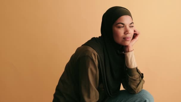 一个有思想的阿拉伯年轻女人正凝视着因米色背景而与世隔绝的侧面 — 图库视频影像