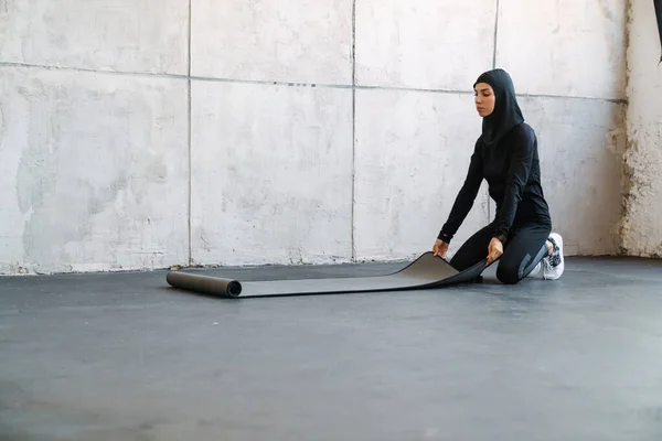 Başörtülü Genç Müslüman Kadın Içeride Spor Paspası Açıyor — Stok fotoğraf