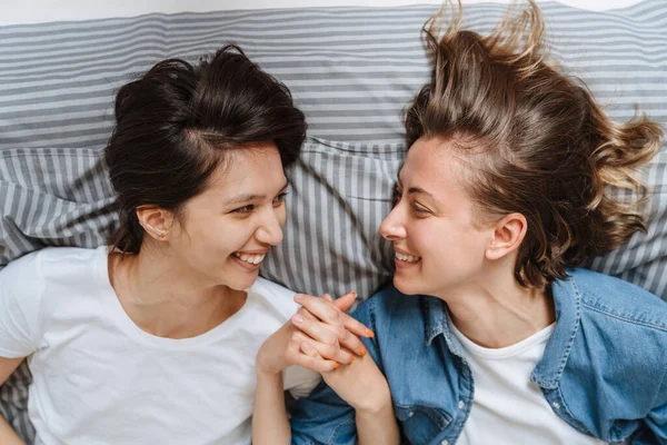 Retrato Sonriente Pareja Chicas Lesbianas Cogidas Mano Cama Sala Luz —  Fotos de Stock