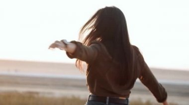 Güzel bir kadın yazın doğada dönüp poz veriyor.