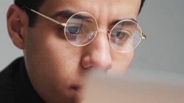 Düşünen bir Arap 'ın yakın plan görüntüsü ofiste bilgisayarını kullanarak çalışıyor.